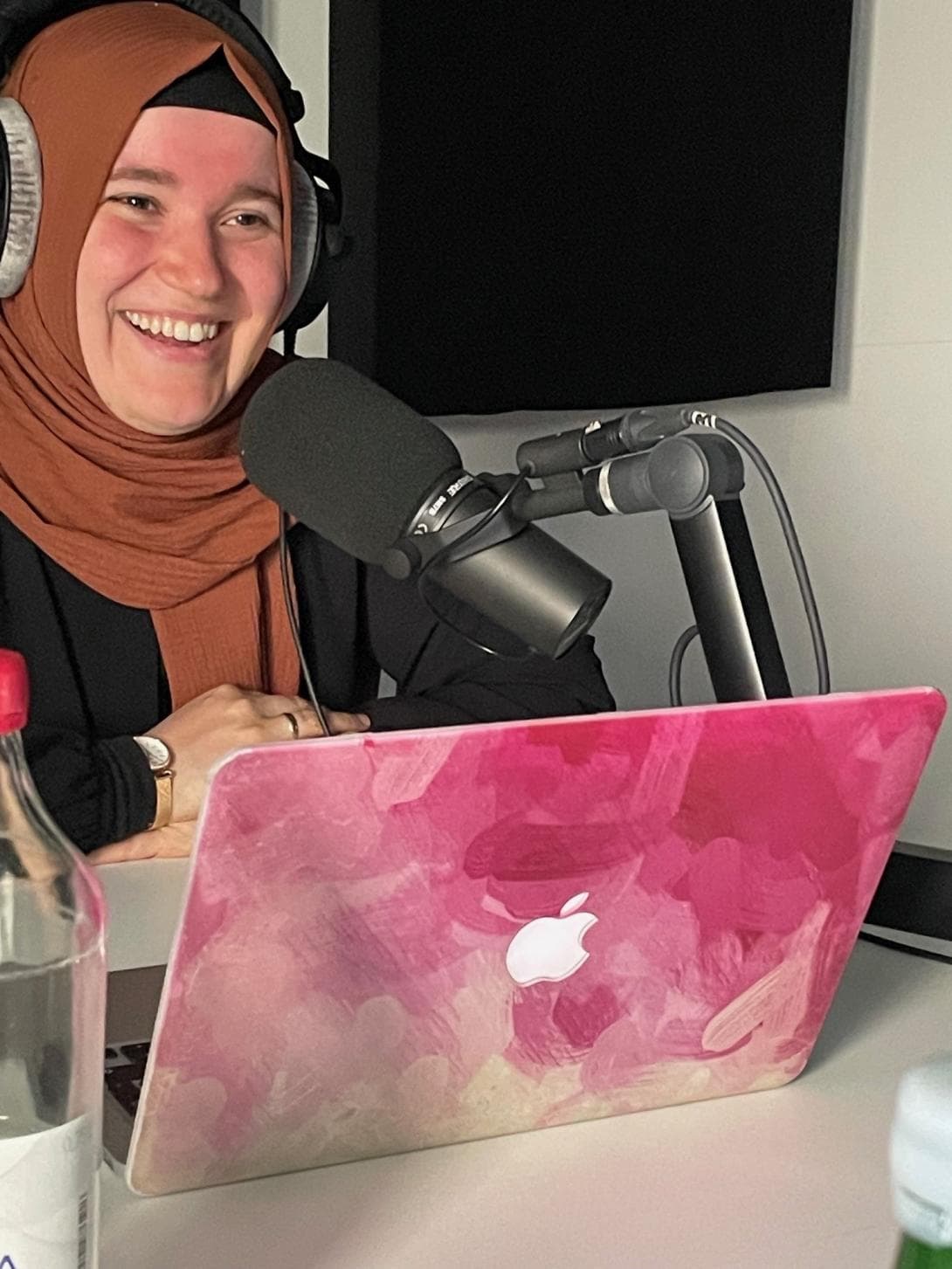 Podcasterin Kübra Dalkilic mit ihrem pink gefärbten Laptop