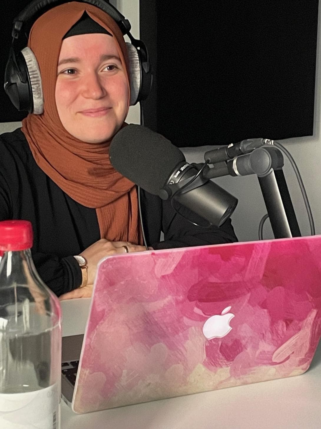 Podcasterin Kübra Dalkilic mit ihrem pink gefärbten Laptop