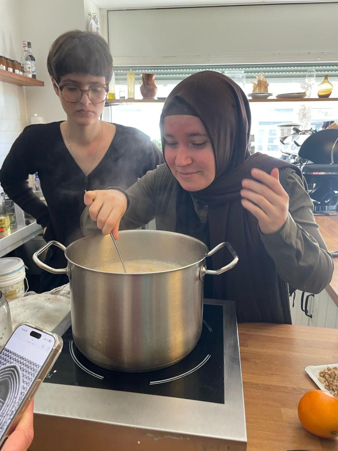 Rebecca Rogowski und Kübra Dalkilic am Herd, wo in einem großen Topf die süße Noah Suppe kocht